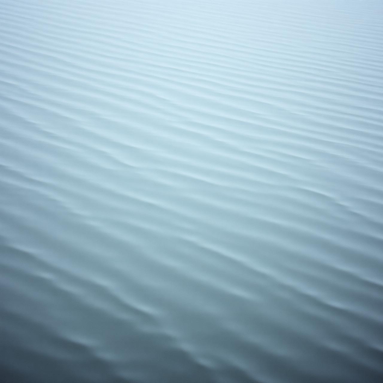 A silver-grey water surface holding the faintest ripple.